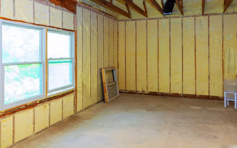 Room with insulated walls around new windows, ready for drywall